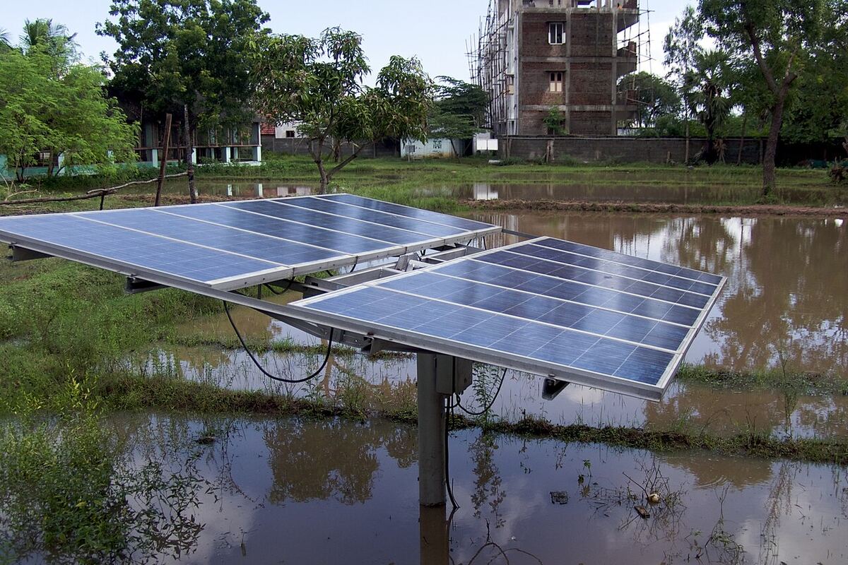 Ground-mounted solar panel array on open farmland in rural India